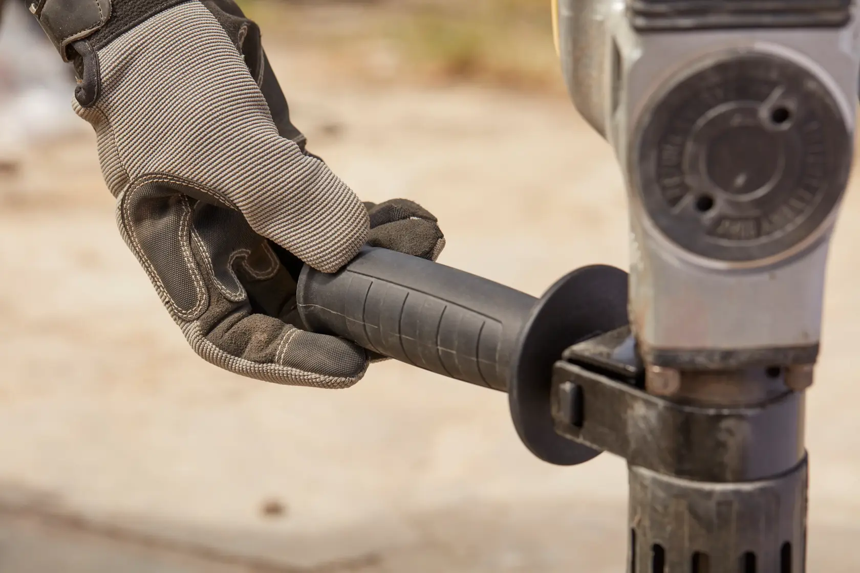 Photo of STANLEY SFMEH220K-QS rotary hammer handle held by gloved hand, close-up view.