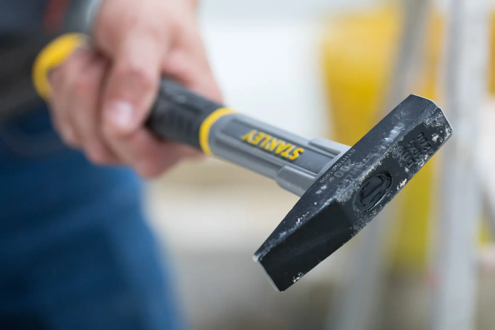 Photo of STANLEY STHT0-51906 chisel hammer with black and yellow handle held in a hand.