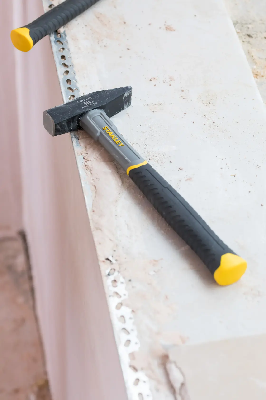 STANLEY STHT0-51908 club hammer with black and yellow handle on a concrete surface, product photography.