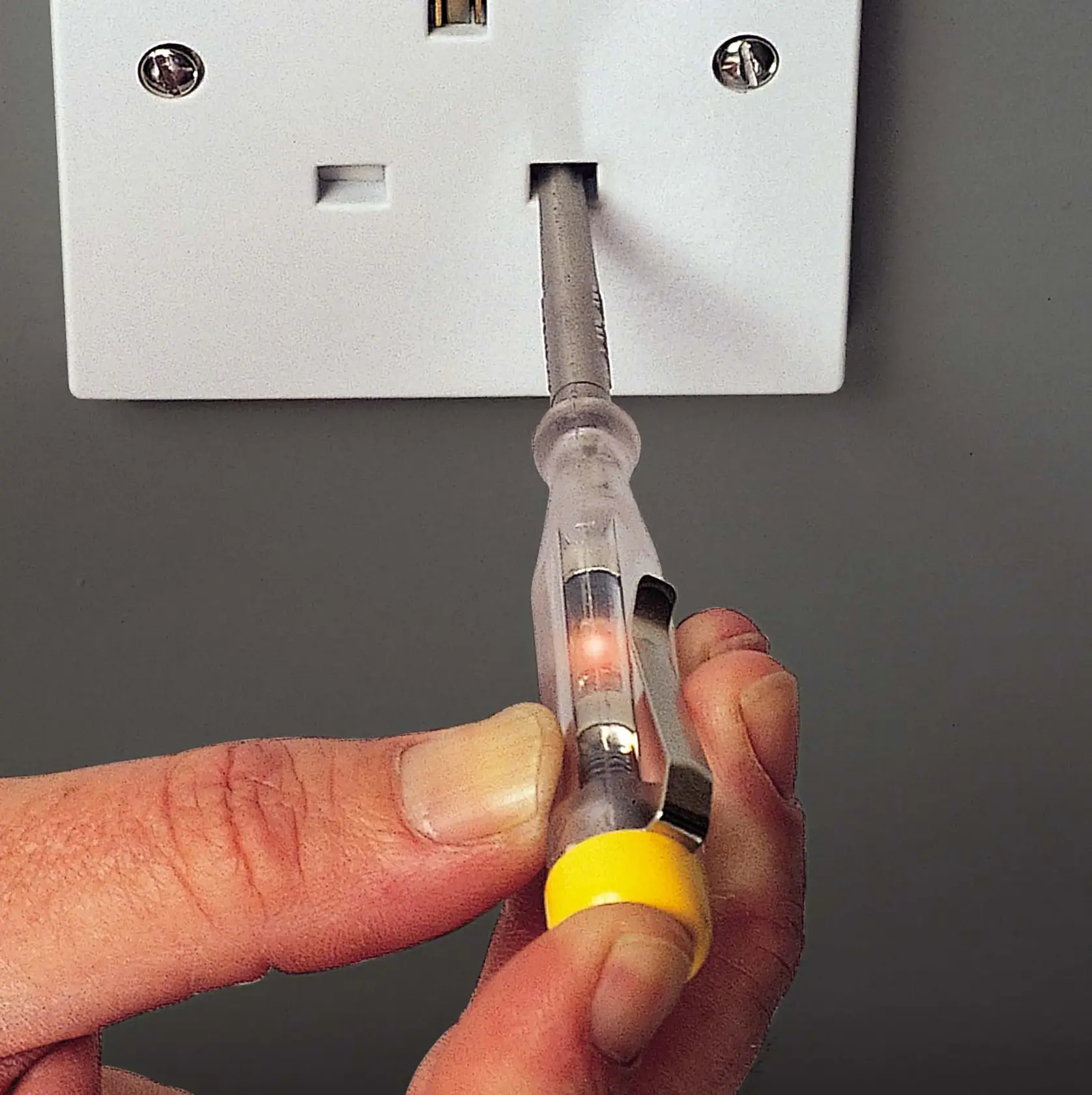 STANLEY STHT0-66121 voltage tester screwdriver in use on electrical outlet, close-up view.