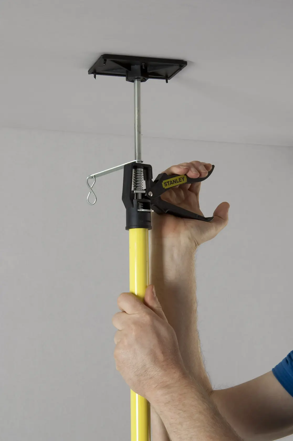 Photo of STANLEY STHT1-05932 support rod being used to brace a ceiling, close-up on handle and yellow pole.