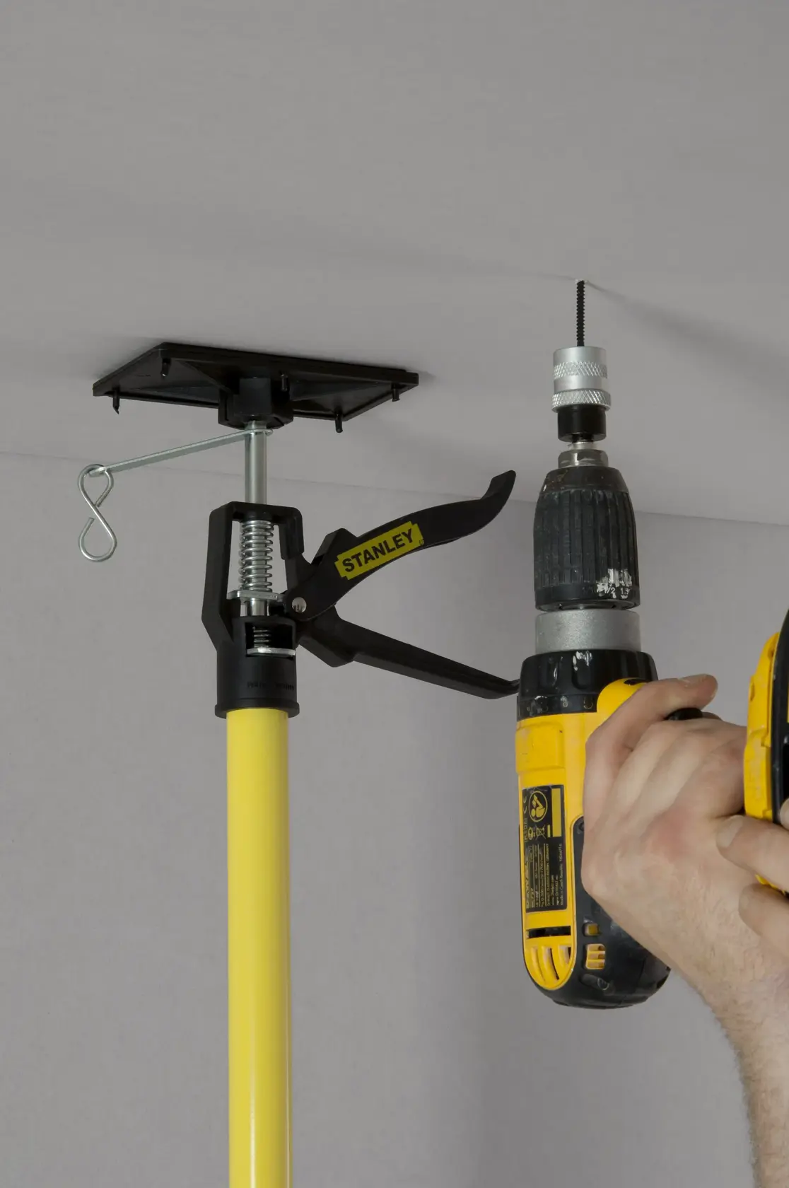 STANLEY STHT1-05932 adjustable drywall support pole in use during ceiling installation.