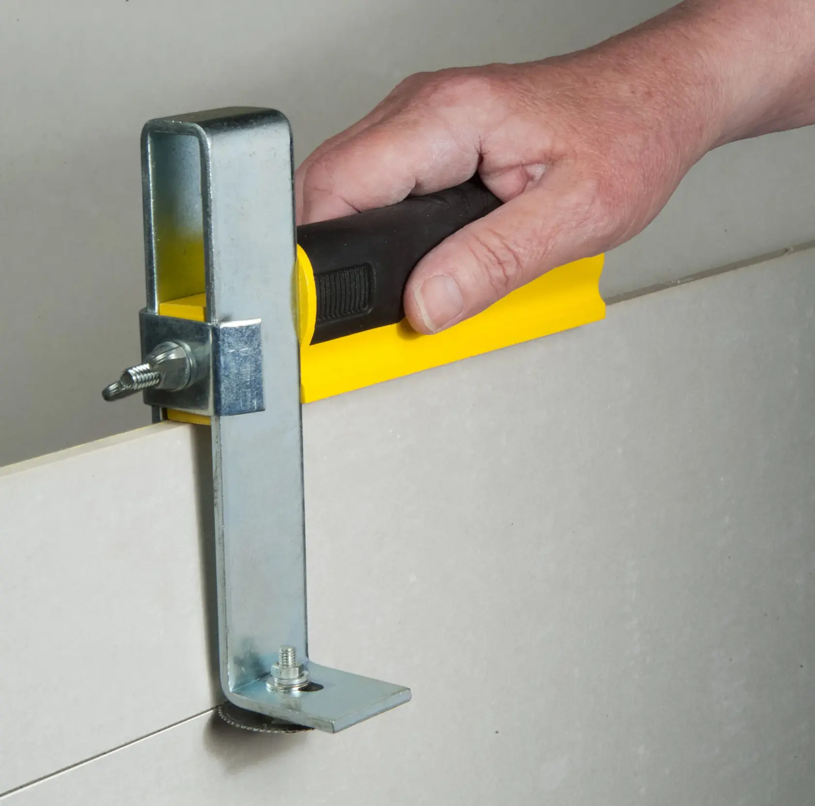 STANLEY STHT1-16069 drywall cutting tool with black and yellow handle in use.