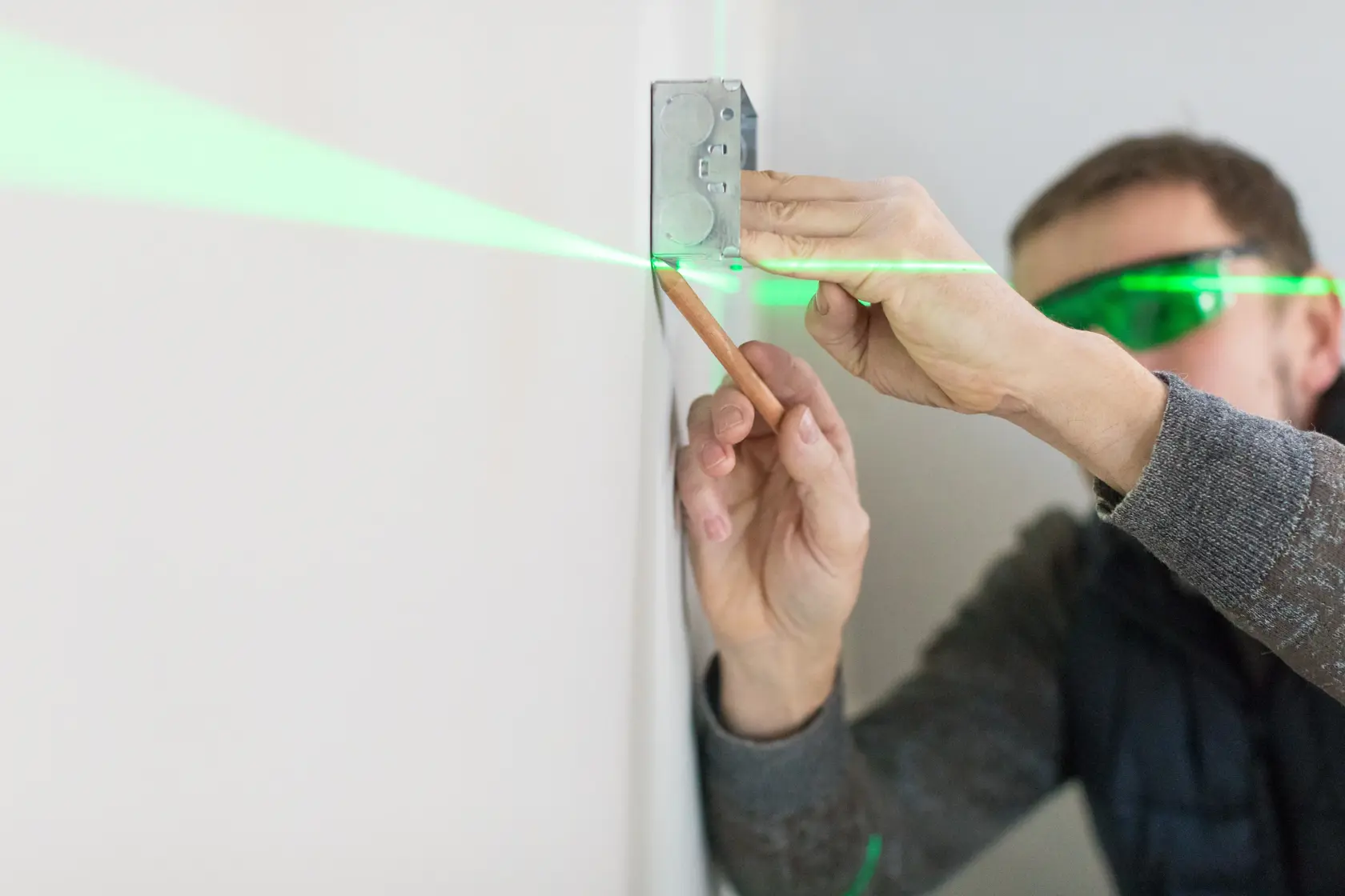 STANLEY STHT1-77367 laser level projecting green line on wall, used for marking position during installation.
