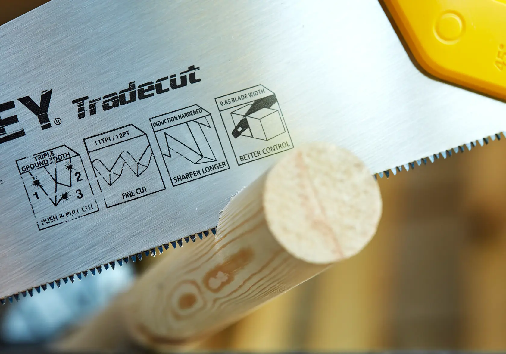 STANLEY STHT20349-1 hand saw close-up cutting wood, showing Tradecut blade details.