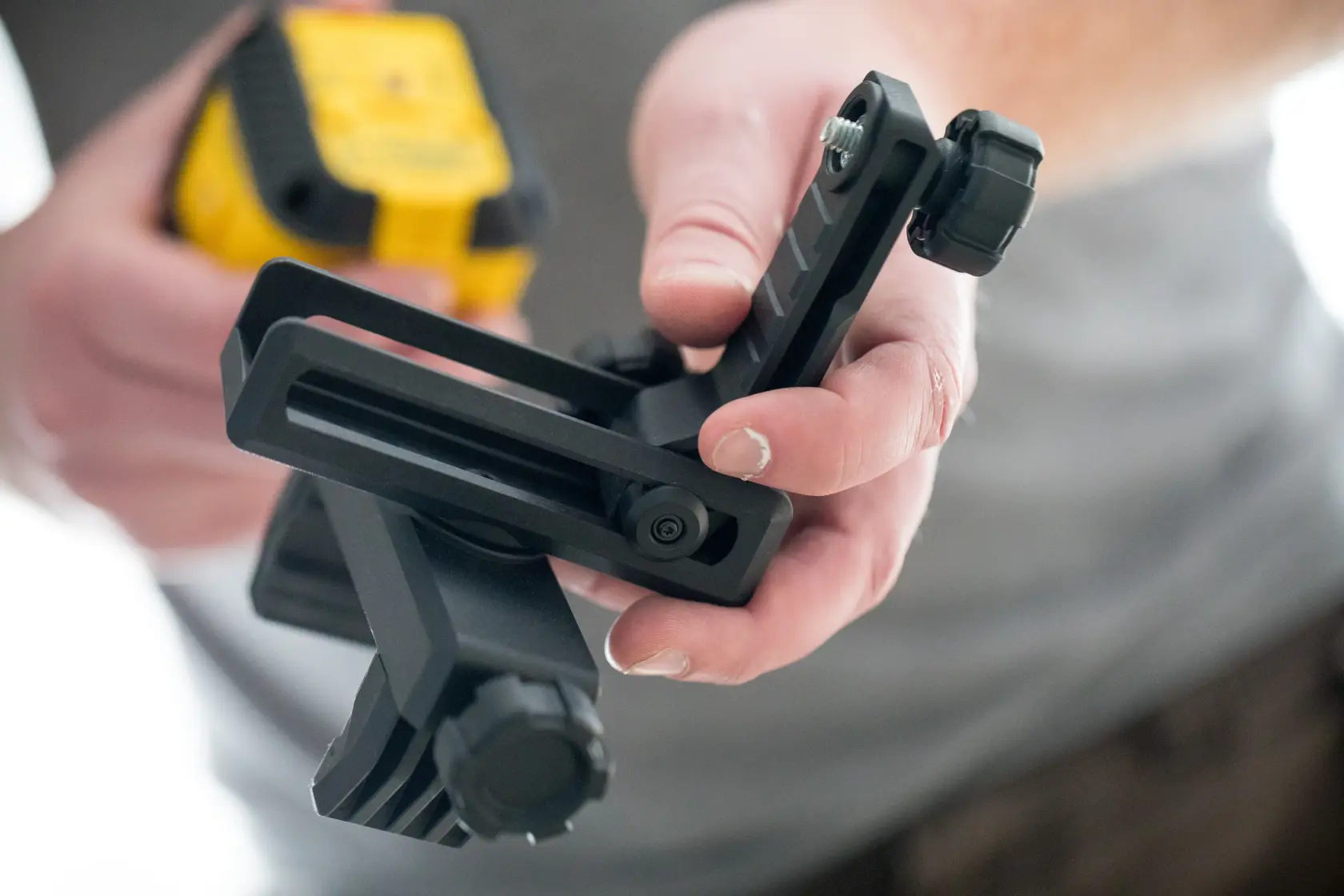 STANLEY STHT77499-1 photography accessory in hand, black adjustable mounting bracket, close-up.