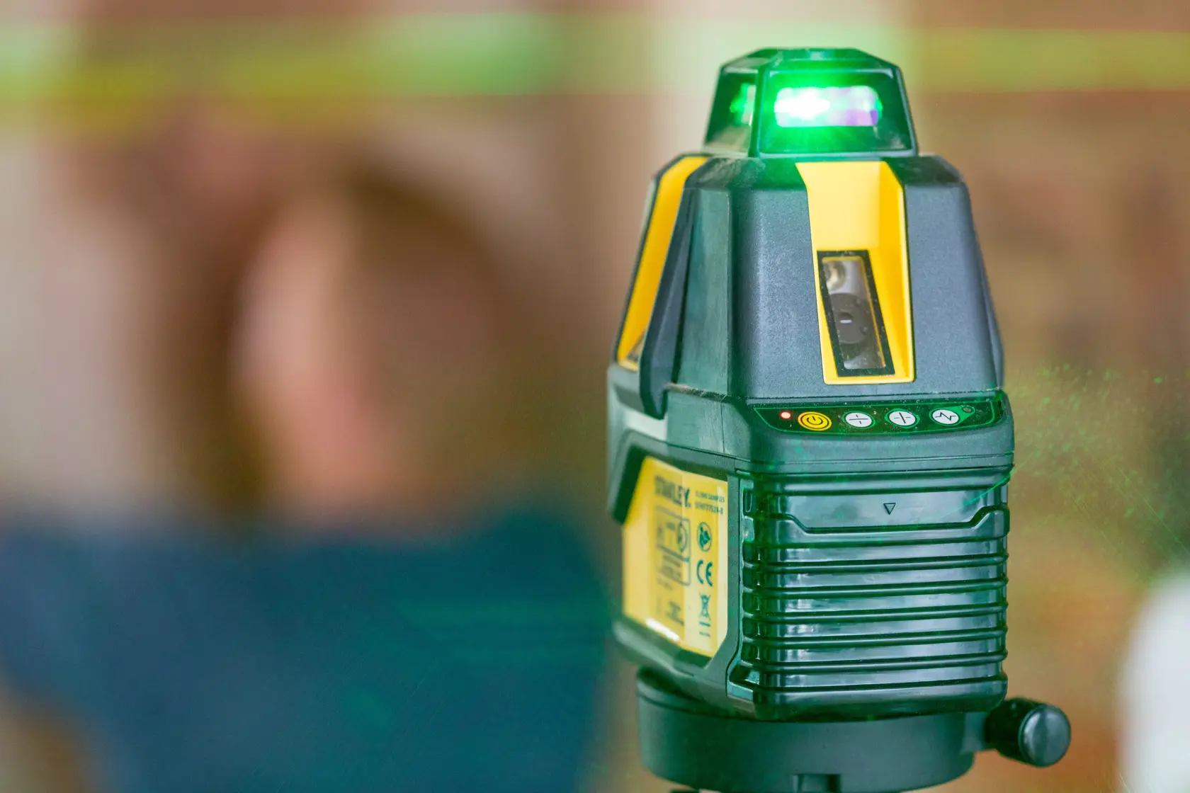 STANLEY STHT77524-1 laser level showing green laser beam in indoor setting, photography close-up.