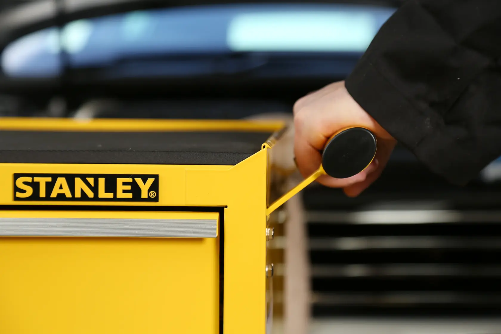 STANLEY STMT1-75063 yellow tool chest with drawer handle being pulled, close-up side angle.