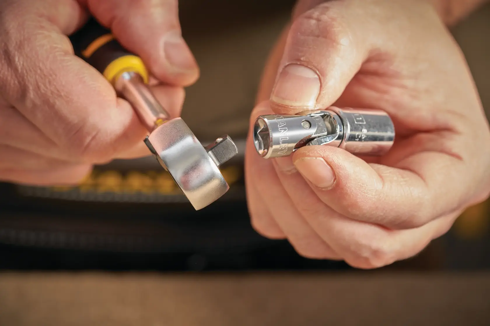 STANLEY STMT86011-0 ratcheting tool and socket in hand, close-up photography of tool connection.