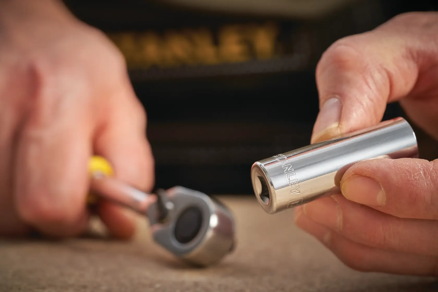Photo of STANLEY STMT86099-0 socket with ratchet handle, close-up on hand holding socket.