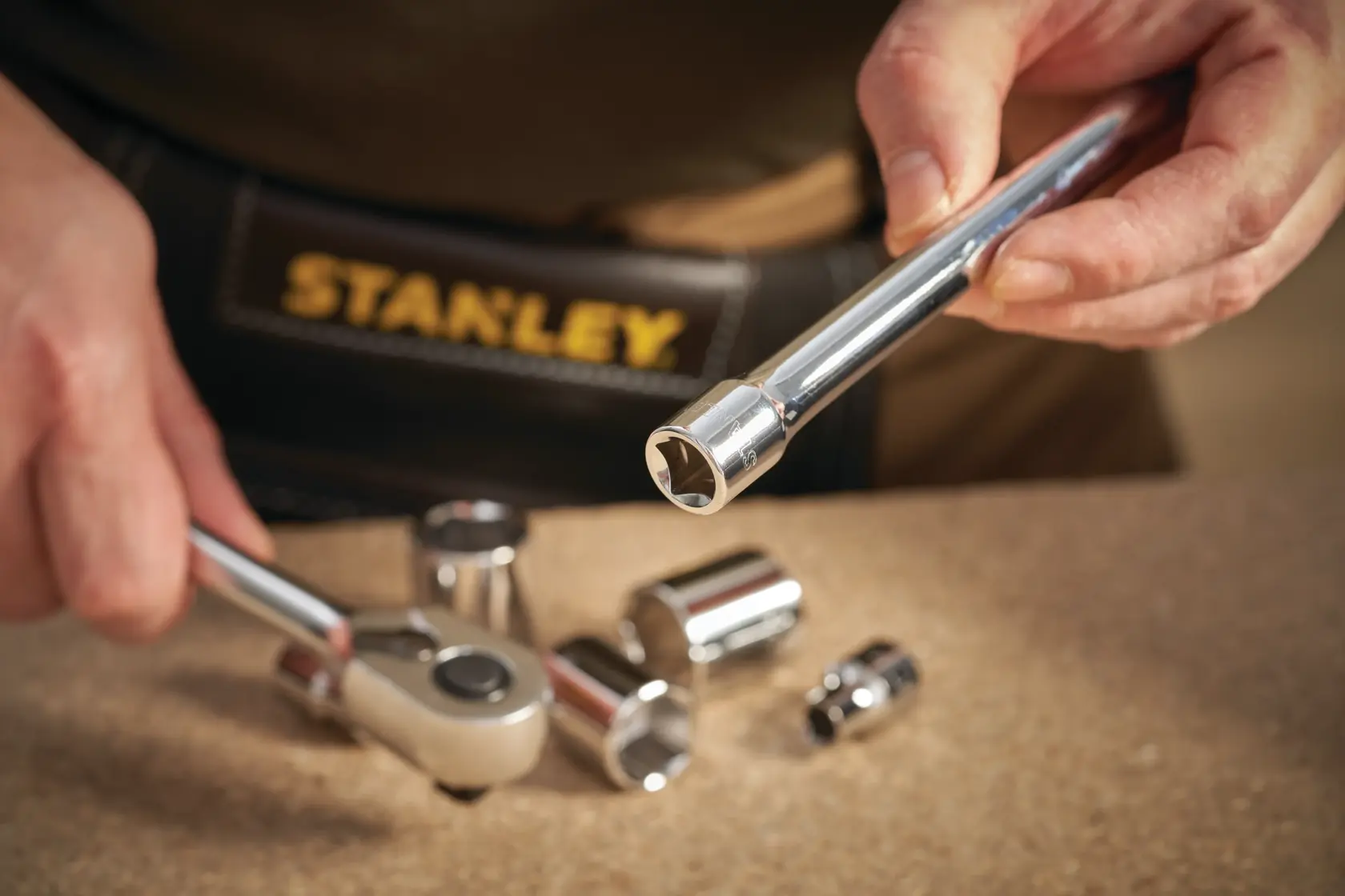 STANLEY STMT86207-0 socket wrench and chrome sockets in close-up on workbench.