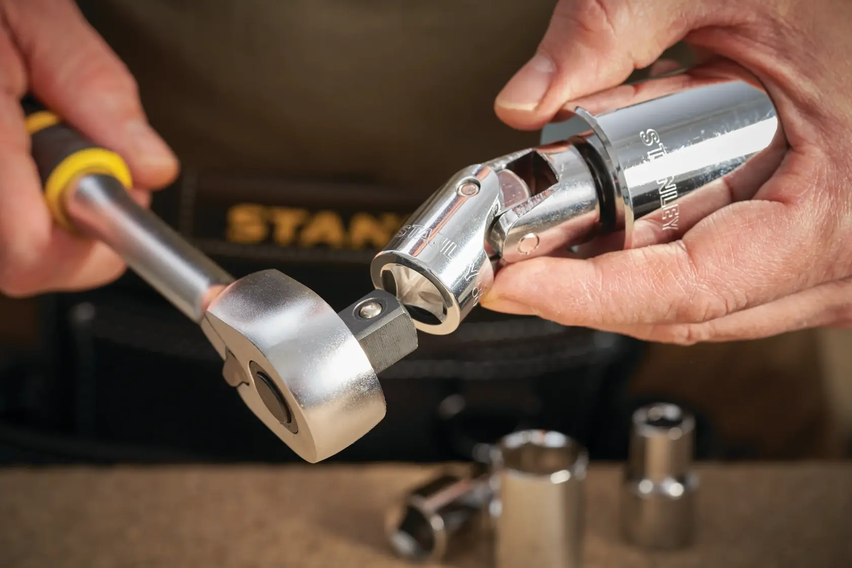 Photo of STANLEY STMT86411-0 ratchet and socket tool in use, chrome finish, close-up.
