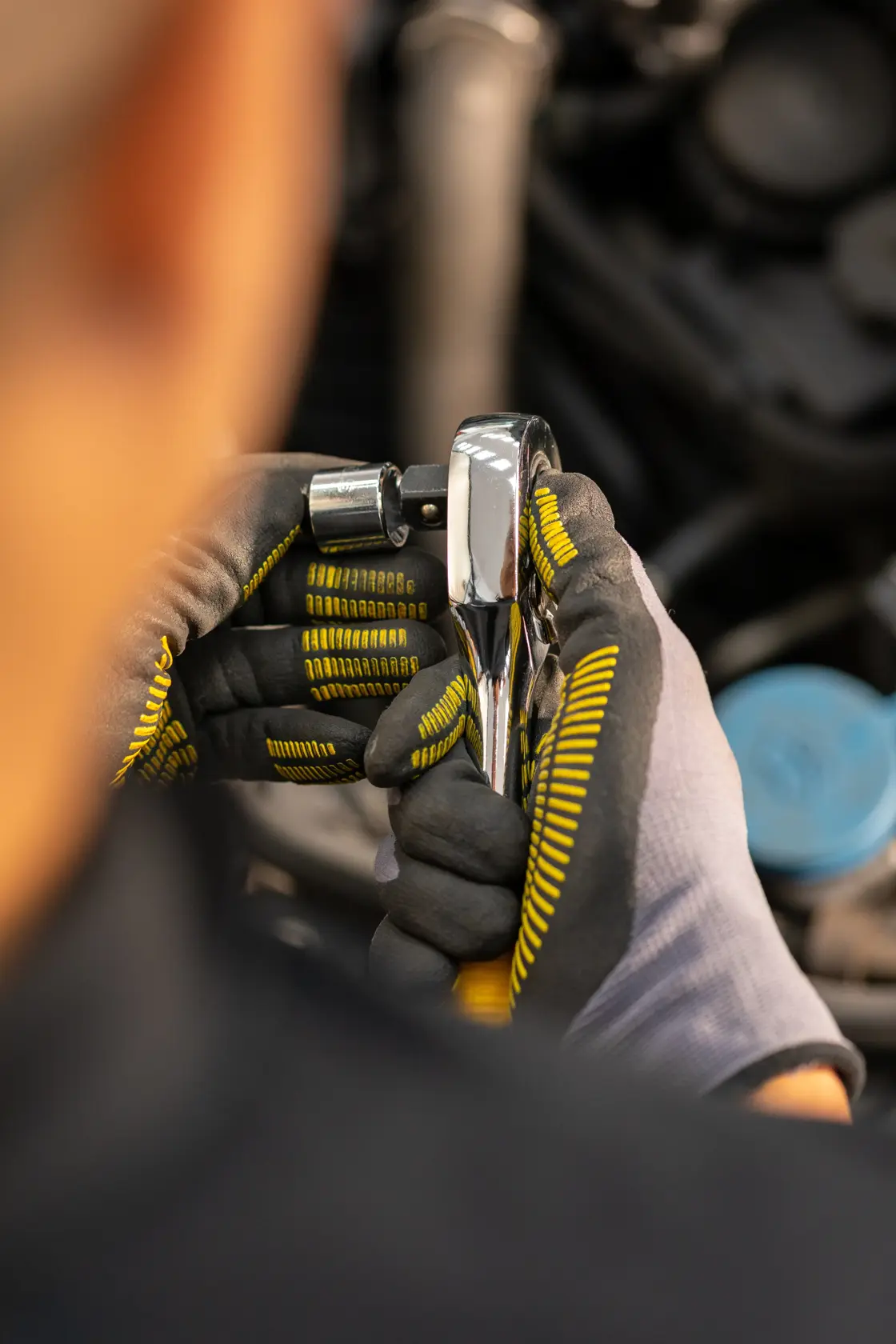 STANLEY STMT86517-0 ratchet wrench held in gloved hands, close-up during mechanical work.