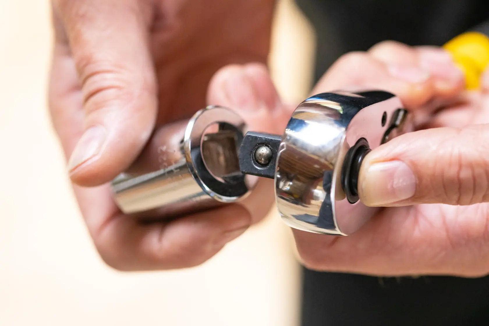 Close-up of STANLEY STMT86520-0 socket wrench and socket, hands attaching parts, tool category.