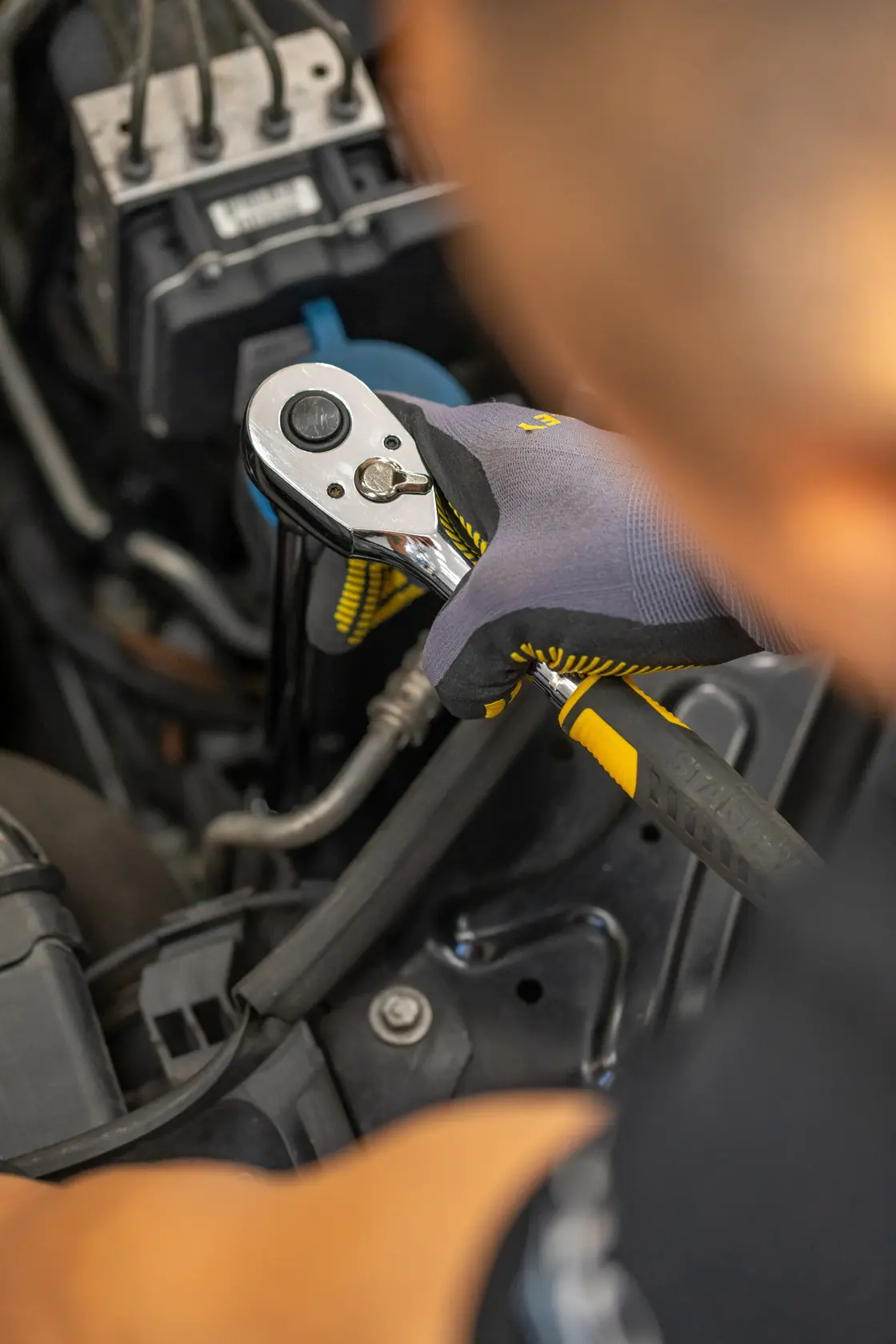 Photo of STANLEY STMT88930-0 ratchet being used on car engine, yellow and black handle visible.