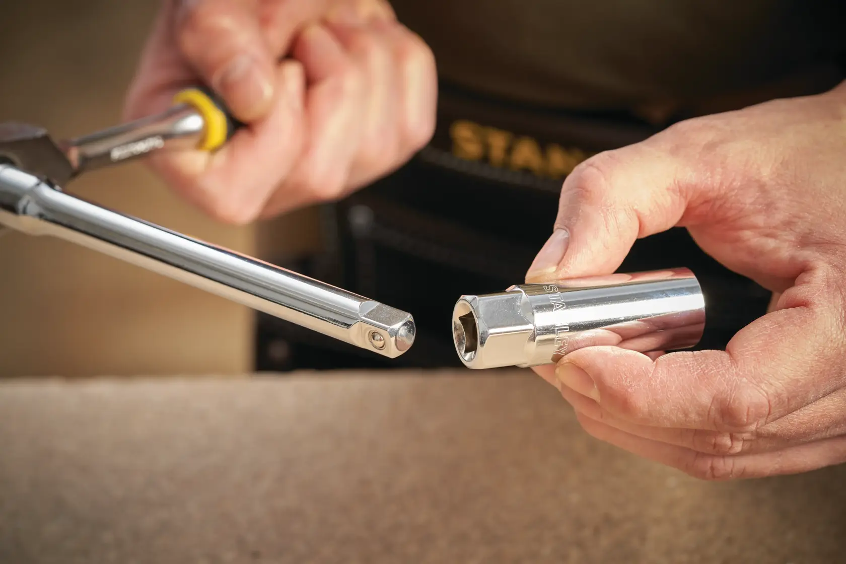 STANLEY STMT88941-0 socket and ratchet tool held in hands, close-up photography with yellow handle.