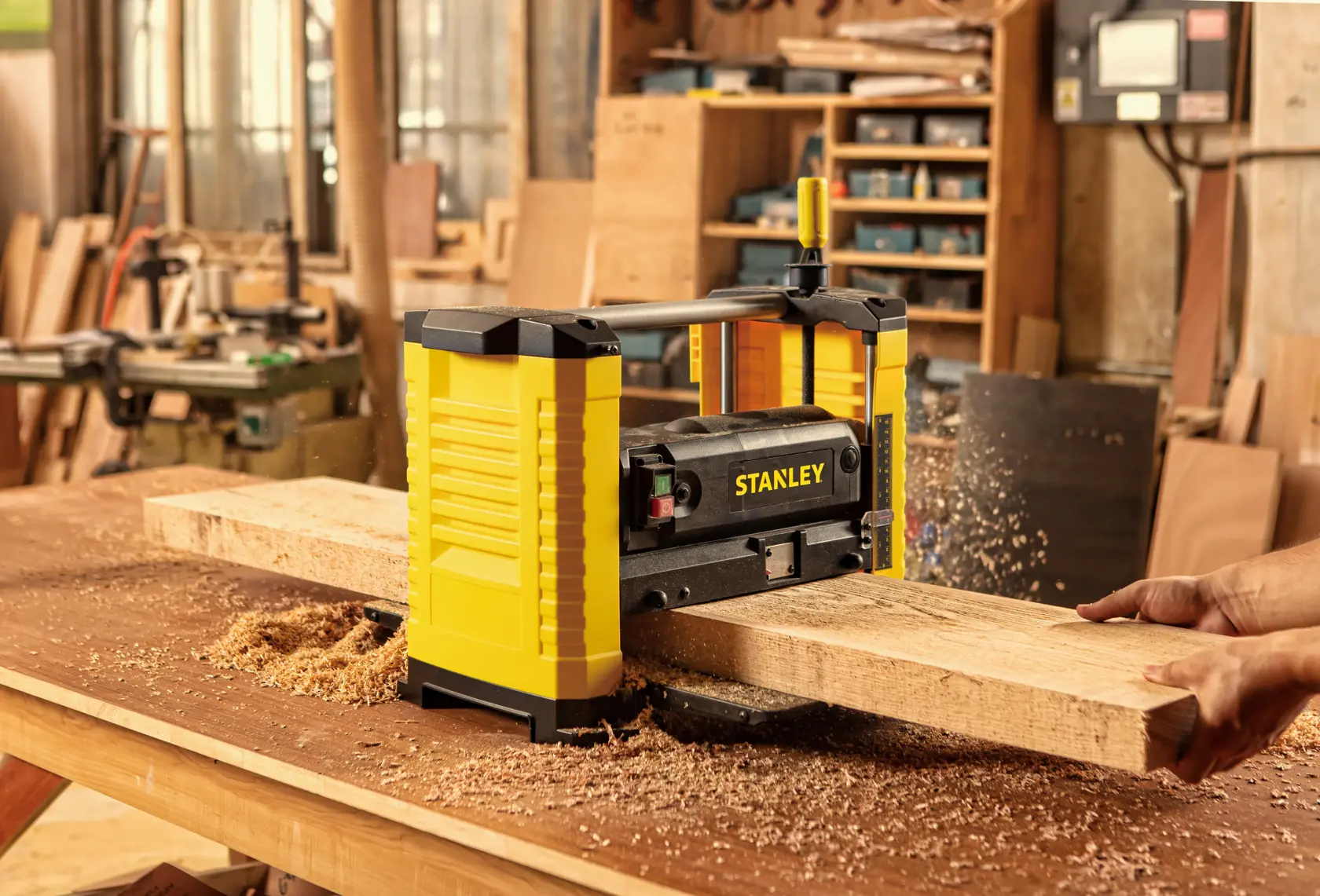 STANLEY STP18-B2 planer in use on wood plank, woodworking shop background, front angle.