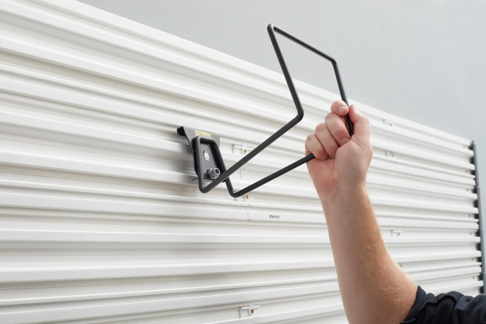 STANLEY STST82604-1 wall-mounted storage hook installation on white panel, side angle.