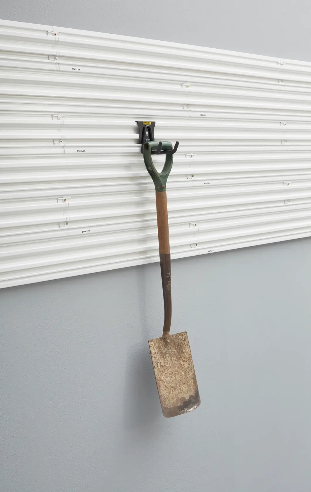Photo of STANLEY STST82607-1 wall panel with metal garden spade hanging on storage hook, front view.
