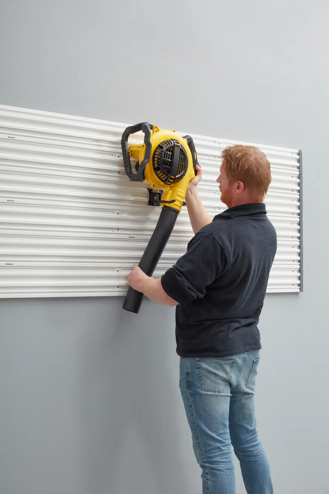 STANLEY STST82609-1 photography of wall panel used to hang a yellow leaf blower.