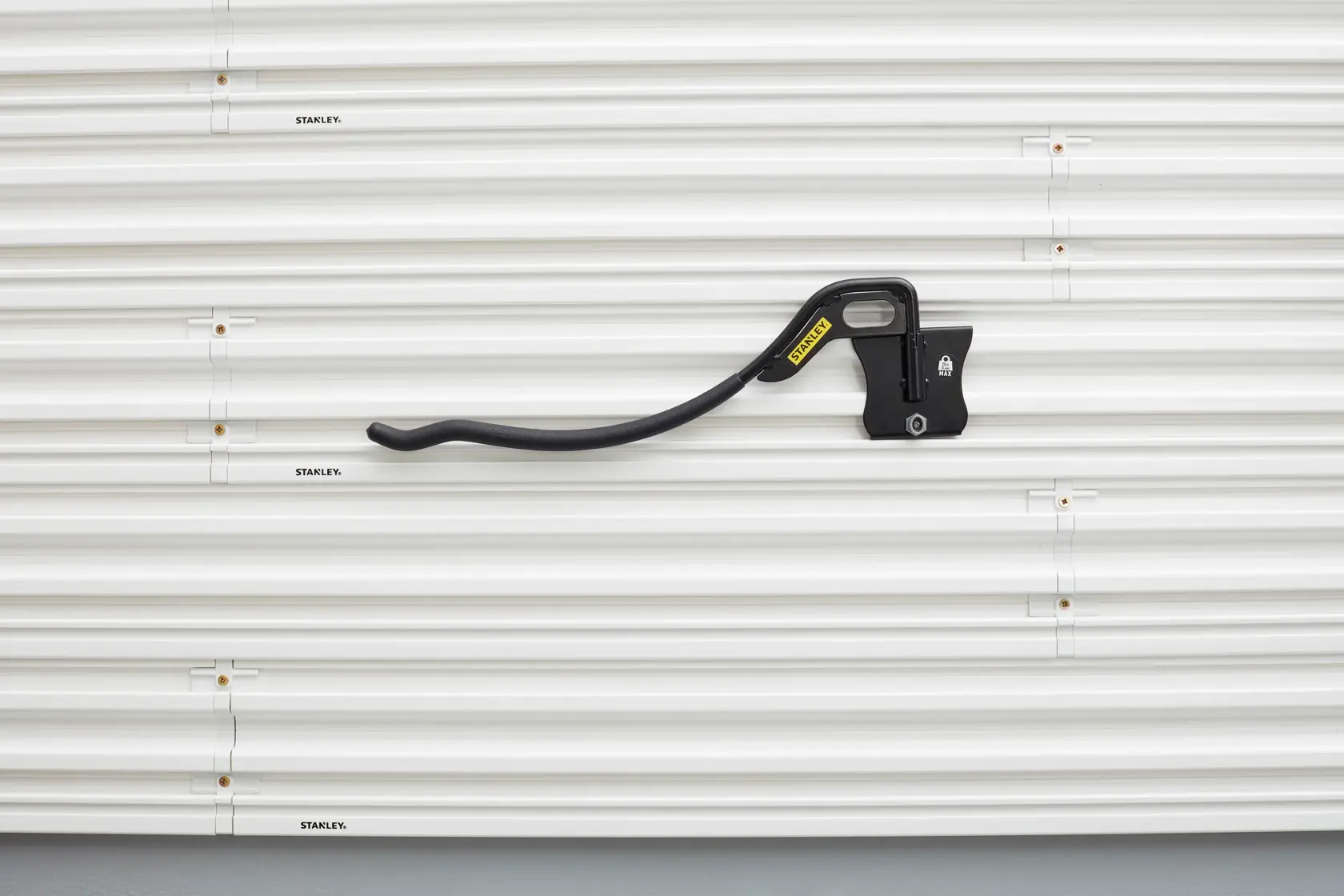 STANLEY STST82615-1 black tool holder on ribbed white storage panel, front view photography.