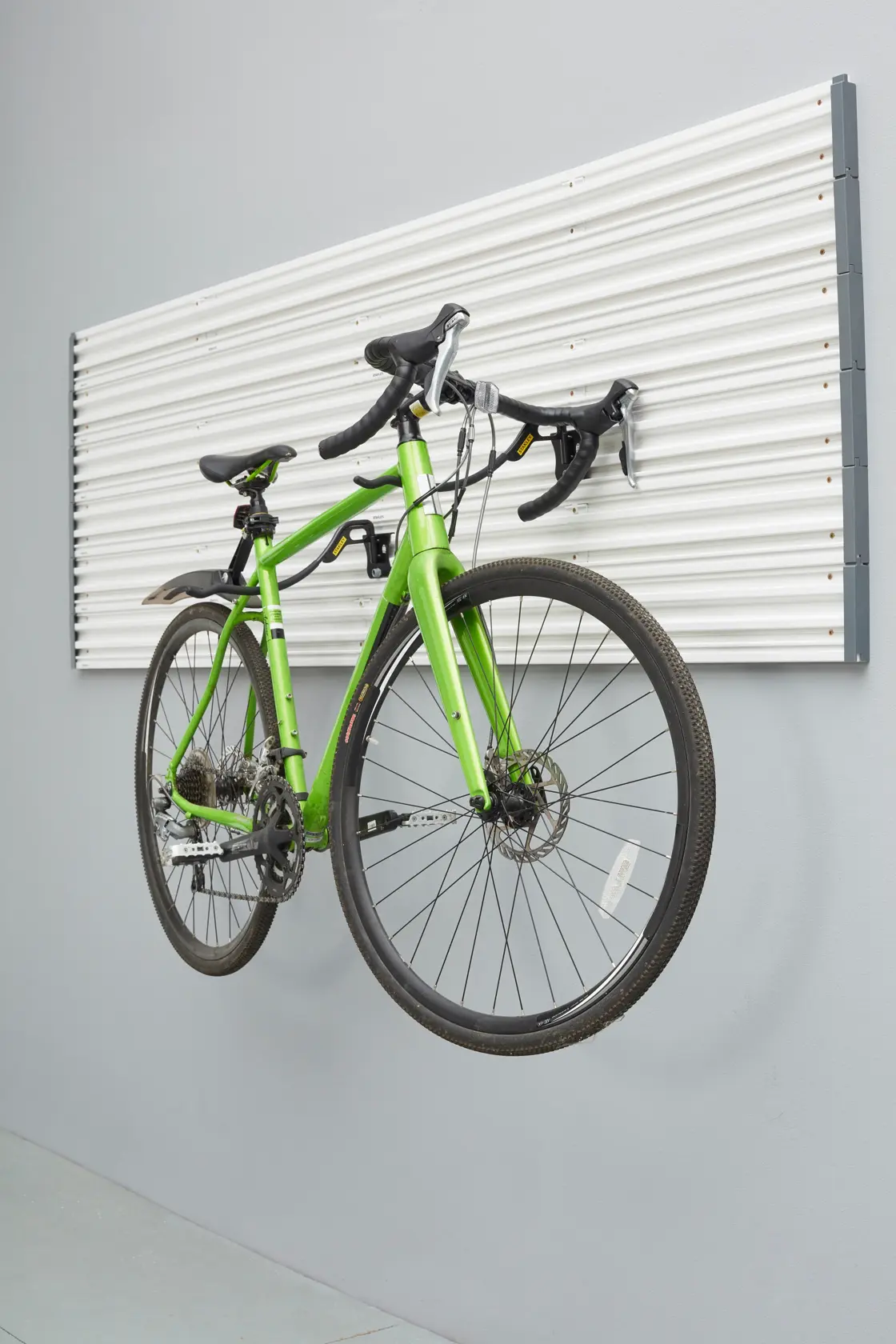 STANLEY STST82615-1 wall-mounted panel with green bicycle hanging, side angle photo.