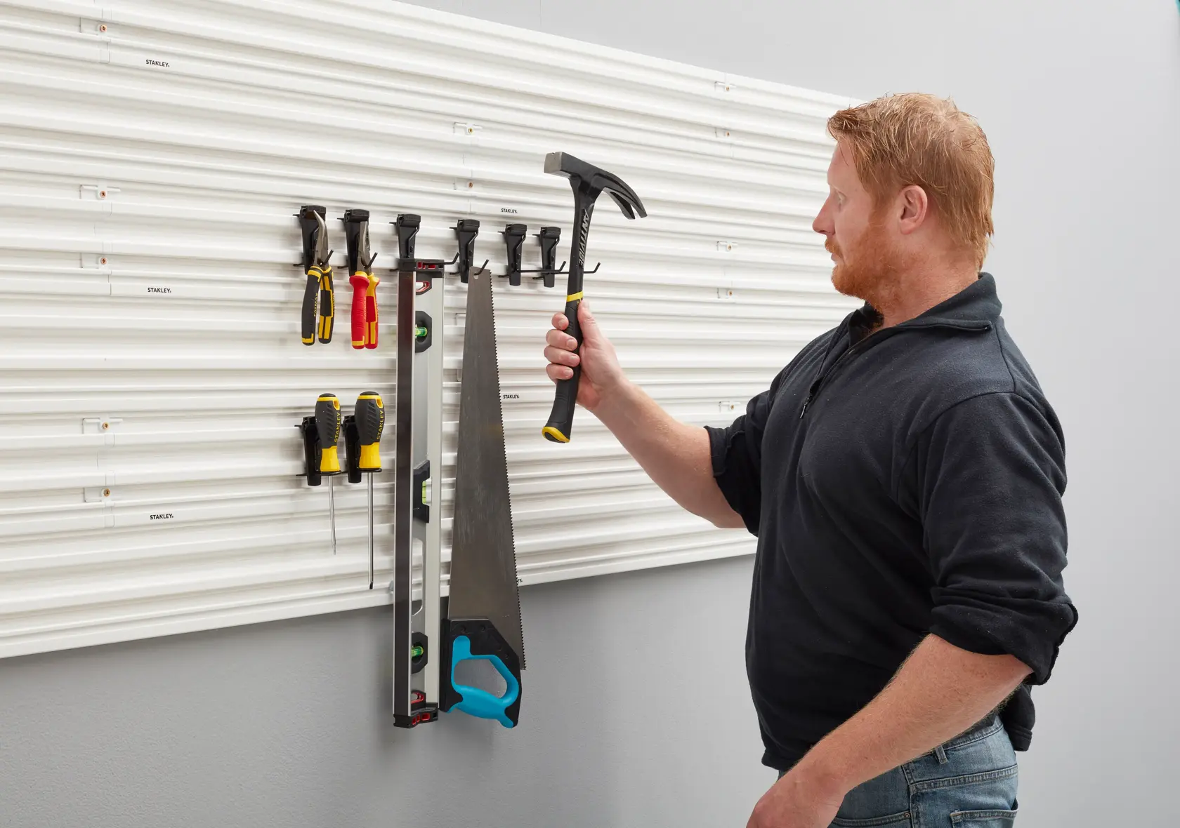 Photo of STANLEY STST82617-1 tool storage wall panel with hand tools hanging, front angle.