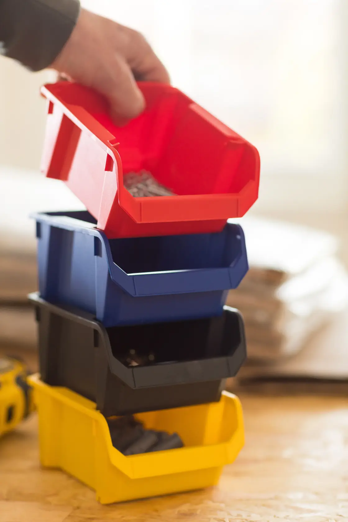 STANLEY STST82736-1 photography showing a hand lifting a red storage bin from a stack of multicolor plastic bins.