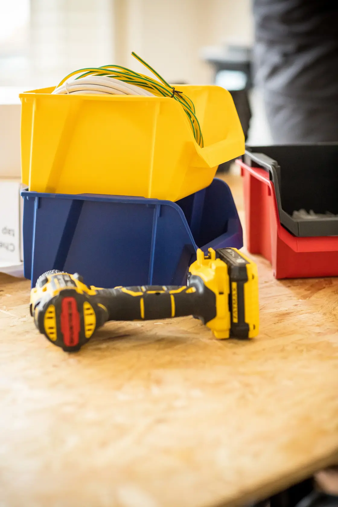 STANLEY STST82740-1 storage bins in yellow, blue, red with tools on wood surface, photography angle.