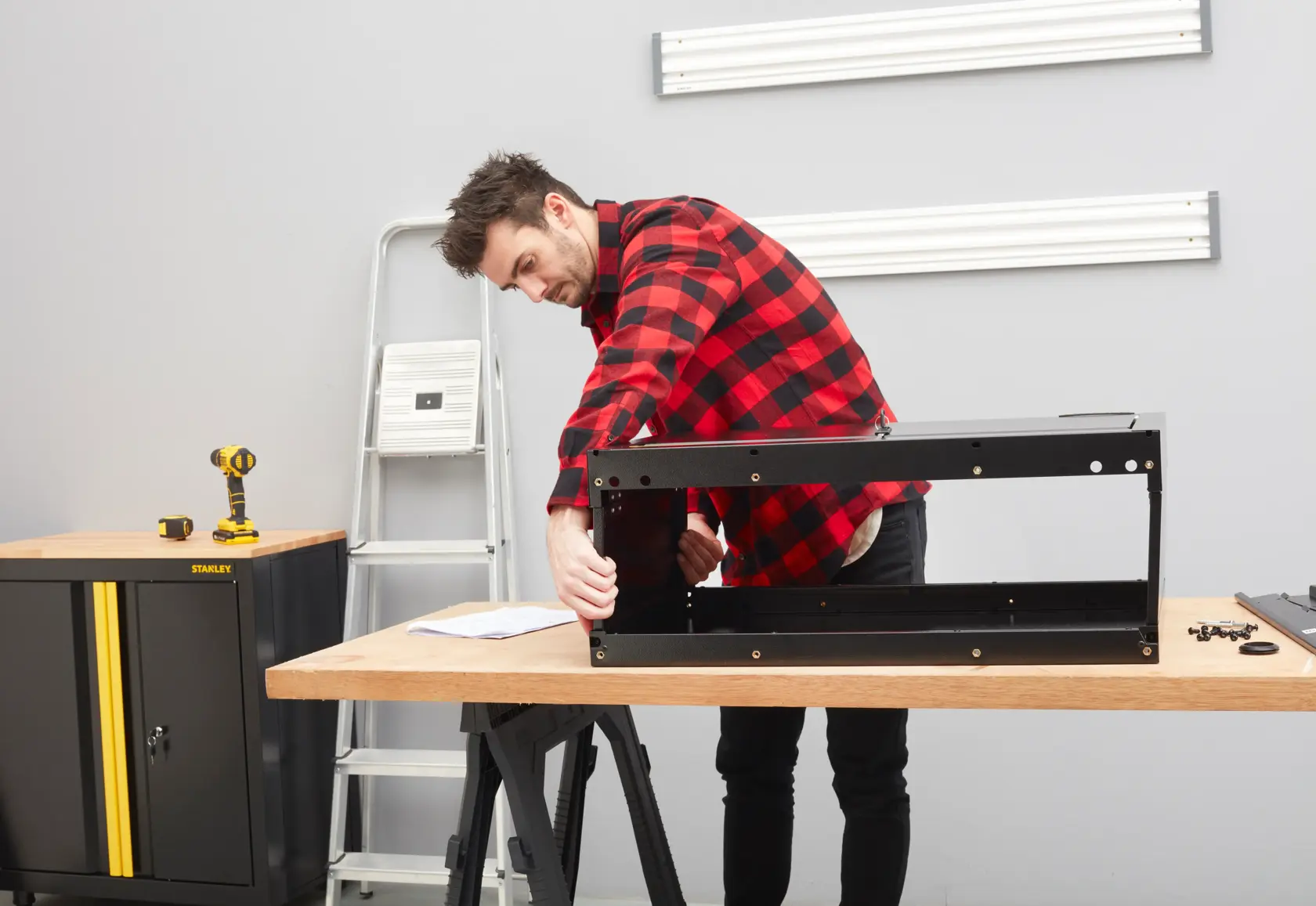 STANLEY STST97599-1 cabinet assembly in workshop setting with tools and wooden workbench.